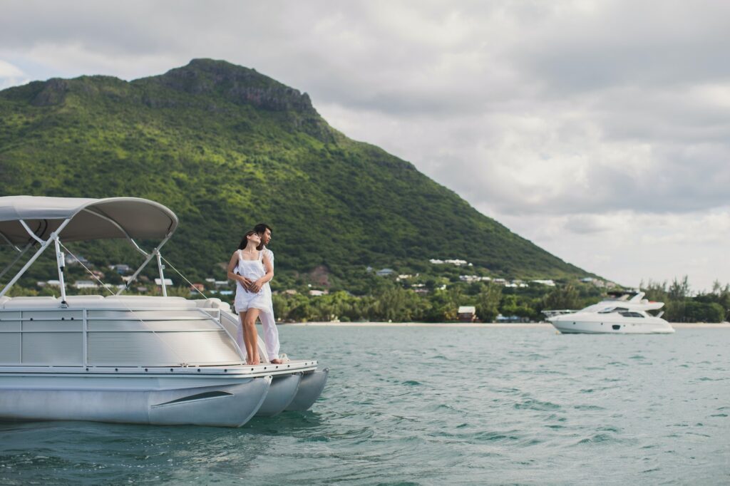 Young couple is traveling on a yacht in the Indian ocean. On the bow of the boat
